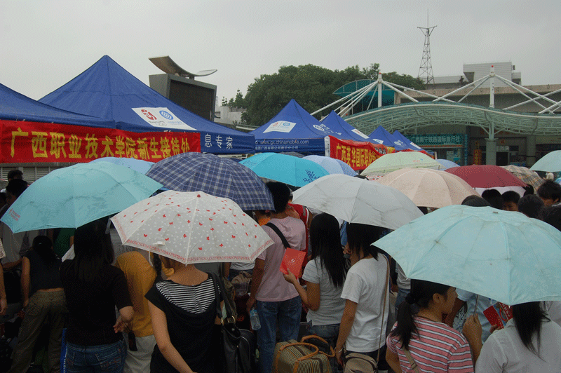 火辣的太阳让新生们不得不拿出了雨伞