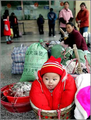 妈妈的背篓：1月25日，成都的长途汽车站，一个婴儿在竹篓里等待去买票的妈妈。每年的这个时候，人们都忙 ...